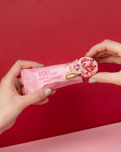 Weiße Pralinis von Linis Bites – Energy Ball-Praline Hybrid, Sorte White Coco Berry – Detailansicht und Verpackungsansicht mit Händen